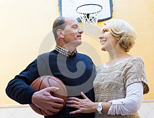 Mature couple playing basketball in patio