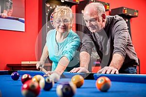 Mature couple playing billiard