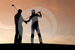 Mature couple playing Golf at sunset