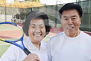 Mature couple playing tennis, portrait