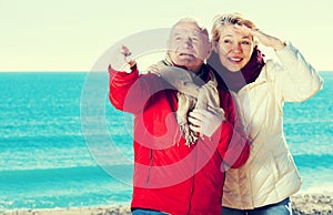 Mature couple pointing on beach