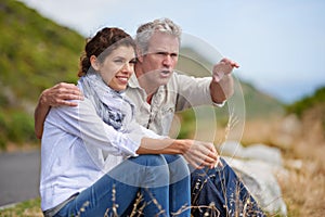 Mature, couple and pointing at nature on holiday, vacation or embrace with love or support in marriage. Happy, woman and