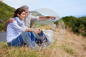 Mature, couple and pointing at nature on holiday, vacation or embrace with love or support in retirement. Happy, man and