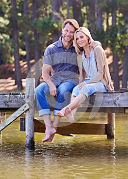 Mature couple, portrait and lake of countryside and together for love in marriage. Happiness, smile and hug by partner