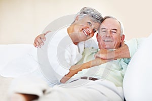 Mature couple relaxing at home. Portrait of loving mature couple smiling while relaxing at home.