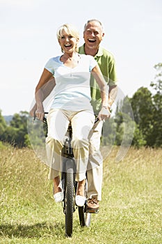 Mature couple riding bike in countryside