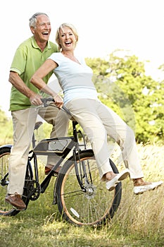 Mature couple riding bike in countryside