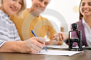 Mature couple signing document in notary`s office