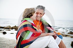 Mature couple sitting on the beach.