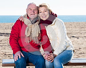 Mature couple sitting by sea