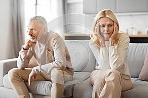 Mature couple sitting separately in thought