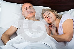 Mature couple sleeping in bed