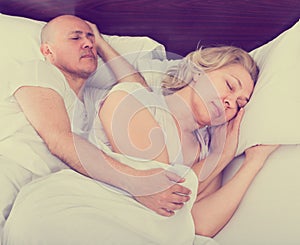 Mature couple sleeping in bed