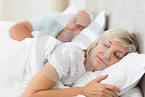 Mature couple sleeping with eyes closed in the bed