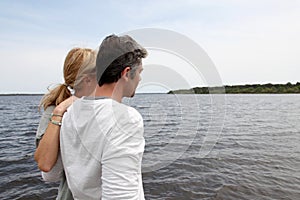 Mature couple standing by the lake admiring nature