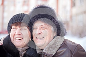 Mature couple on  street in winter near multistory houses