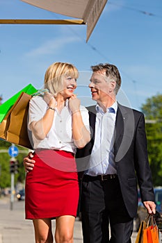 Mature couple strolling through city shopping