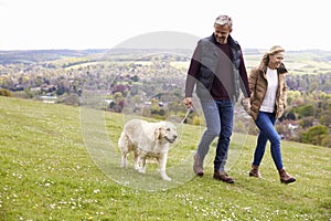 Mature Couple Taking Golden Retriever For Walk