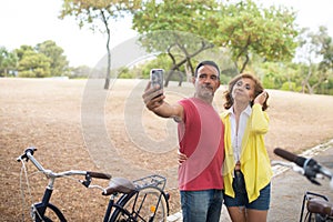 Mature couple taking selfie at bikes outdoors