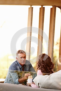 Mature couple, talking and planning in living space with coffee, bonding and discussing life and marriage in day. Older