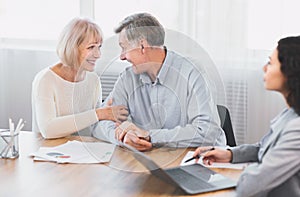 Mature couple talking to financial advisor at office