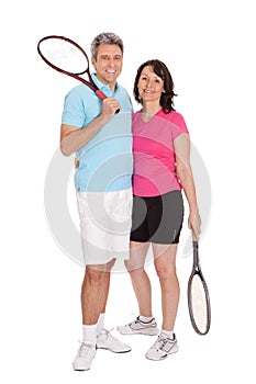 Mature couple with tennis racquets