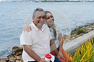 A mature couple in their fifties is sitting in the park embracing each other