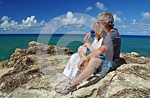 Mature couple top of cliff on tropical island