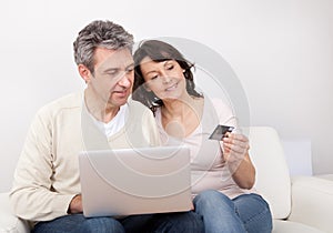 Mature couple using laptop at home