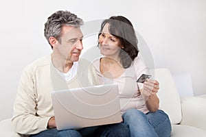 Mature couple using laptop at home