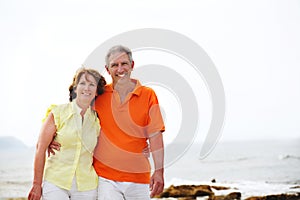 Mature couple walking along the beach.