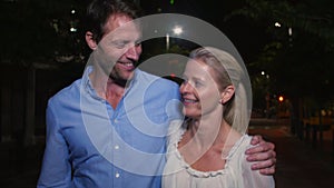 Mature Couple Walking Along Street On Night Out