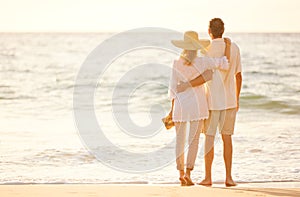 Mature Couple Walking on the Beach at Sunset