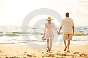 Mature Couple Walking on the Beach at Sunset