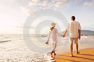 Mature Couple Walking on the Beach at Sunset