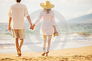 Mature Couple Walking on the Beach at Sunset