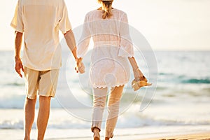 Mature Couple Walking on the Beach at Sunset