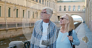 Mature couple walking on street on weekend vacation, looking and enjoying architecture.