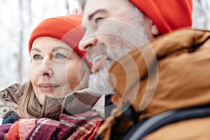 Mature couple in a winter forest feeling happy and peaceful
