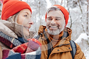 Mature couple in a winter forest feeling happy and peaceful