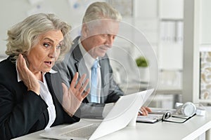 Mature couple working at office