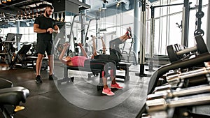 Mature couple working out in gym under trainer's supervision