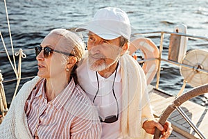 Mature couple wrapped in plaid on yacht