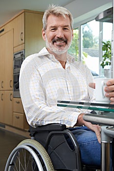 Mature Disabled Man At Home With Hot Drink