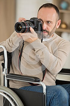 mature disabled photographer focusing camera