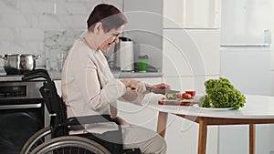 Mature disabled woman cutting vegetables in the kitchen