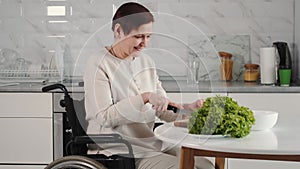 Mature disabled woman cutting vegetables in the kitchen