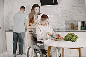 Mature disabled woman cutting vegetables in the kitchen