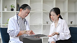 Mature doctor consultation with female patient in hospital.