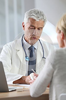 Mature doctor in consultation with patient